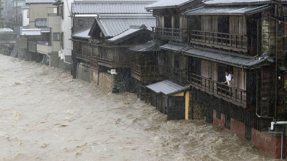 Un hombre mira por el balcón la inundación en Ise. Un hombre mira por el balcón la inundación en Ise.
