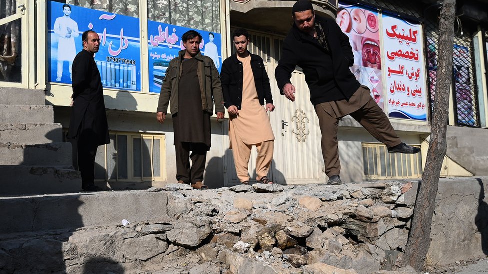 Жители собираются на месте после того, как несколько ракет упали в Хайр-Хане, к северо-западу от Кабула