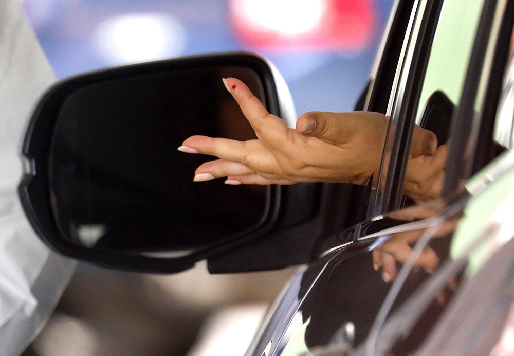 امرأة تمدّ يدها خارج شباك السيارة