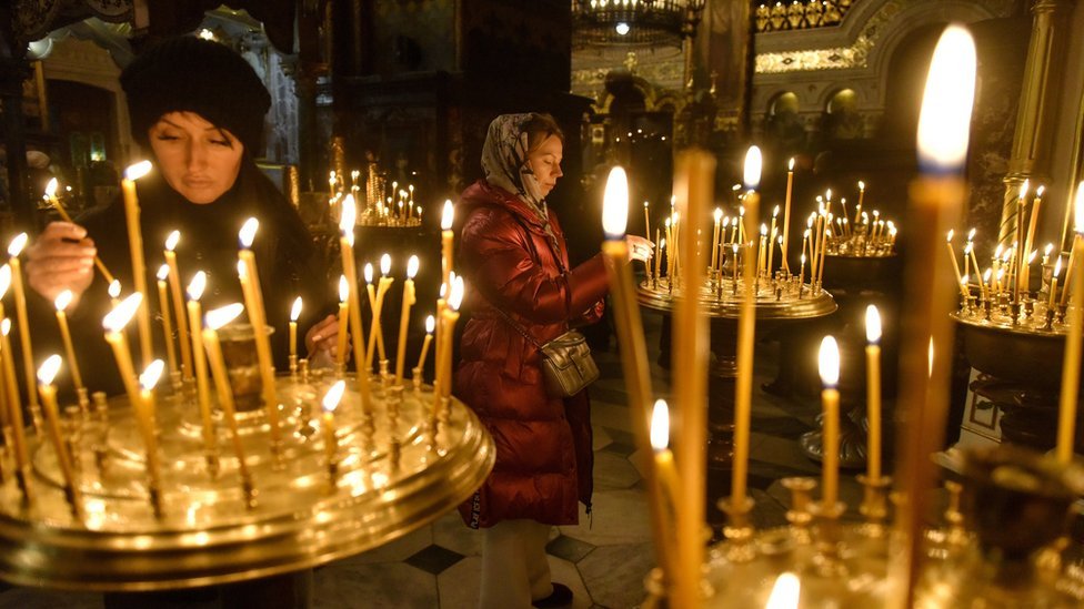 نساء أوكرانيات يشعلن الشموع في الكنيسة