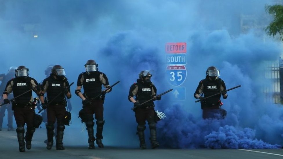 Policías avanzan en medio de una nube de gas