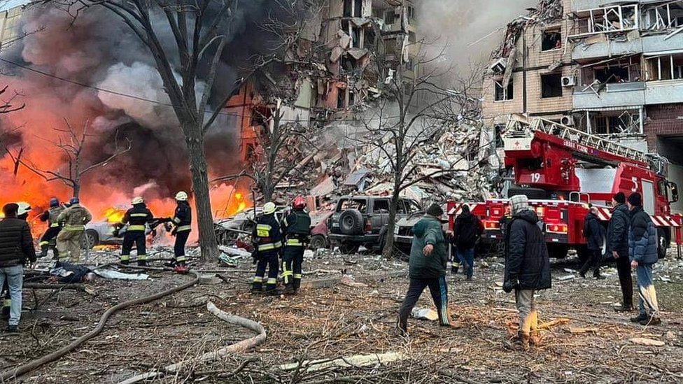 Rescuers and local residents are seen at a site of an apartment building heavily damaged by a Russian missile strike, amid Russia's attack on Ukraine, in Dnipro, Ukraine