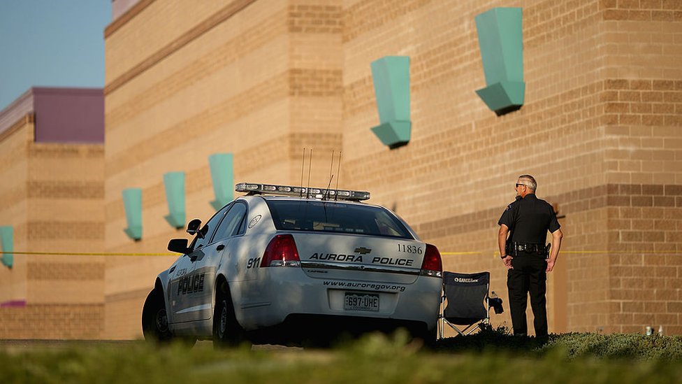 Полиция Авроры охраняет периметр кинотеатра на следующий день после массового расстрела в 2012 году в Авроре, штат Колорадо