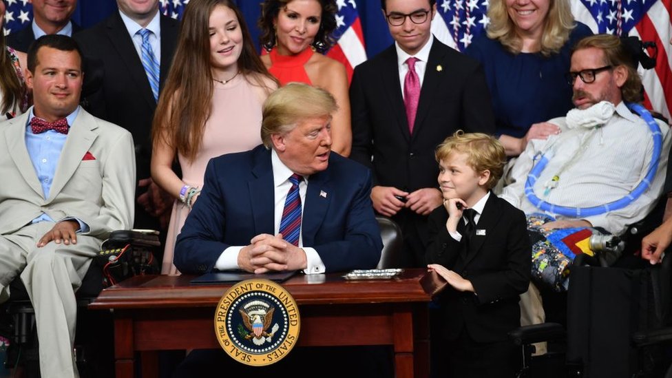 Trump con pacientes mientras firma la ley 