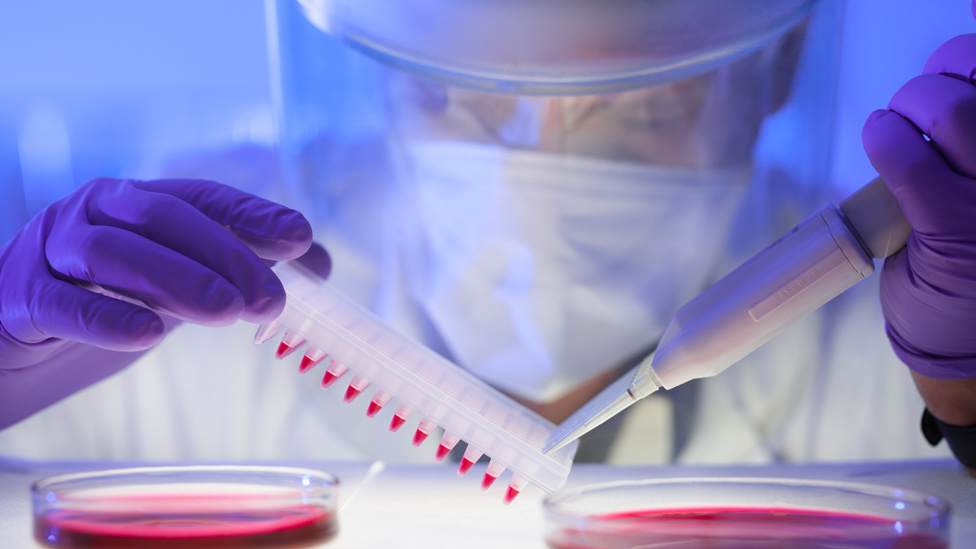 Científico con traje protector en el laboratorio