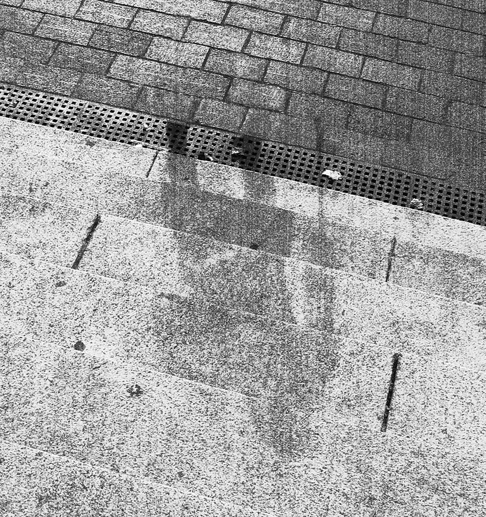 A shadow of a person is marked on stone steps