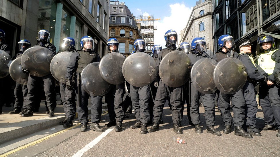 Полиция держит щиты на лондонских протестах G20 в 2009 году