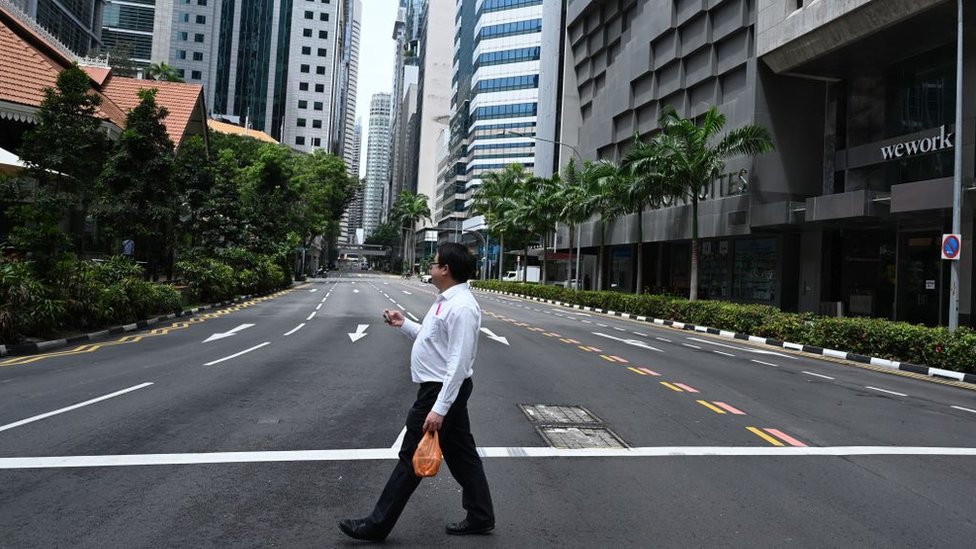 Un hombre camina en una calle vacÃ­a de Singapur