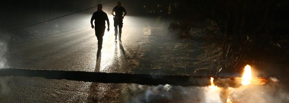 Местные жители идут по перекрытой лесом дороге, сожженной лесным пожаром в деревне Мравинце, Сплит