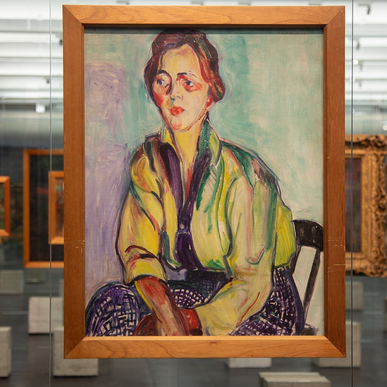 Exibição do quadro A Estudante de Anita Malfatti no MASP. A obra é um retrato colorido de uma mulher sentada em uma cadeira