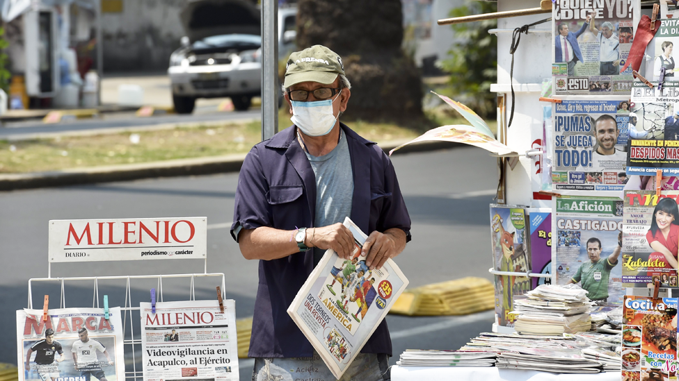Hombre con máscara en un kiosco en la calle en México