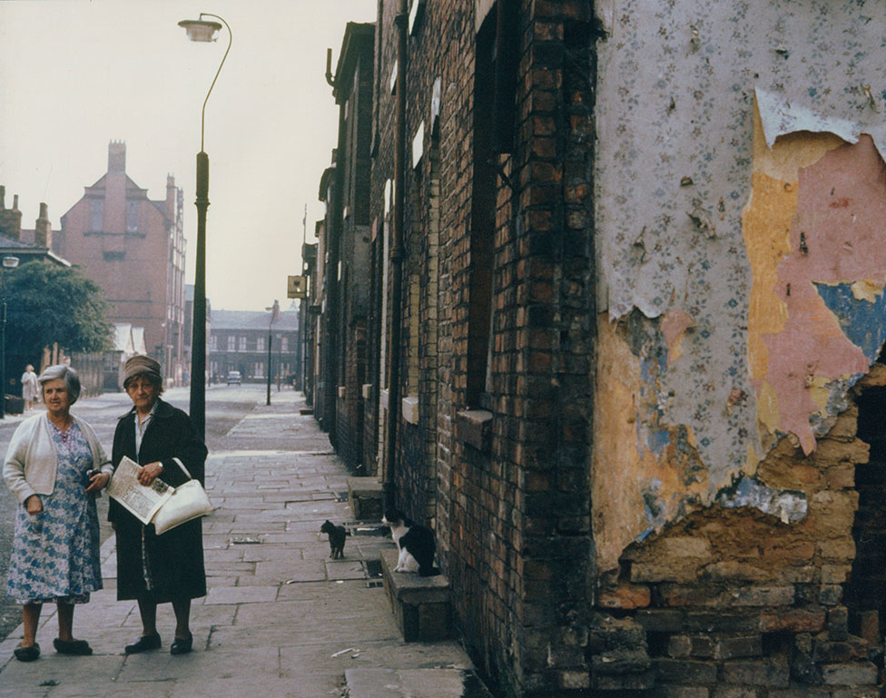Две женщины стоят на заброшенной жилой улице