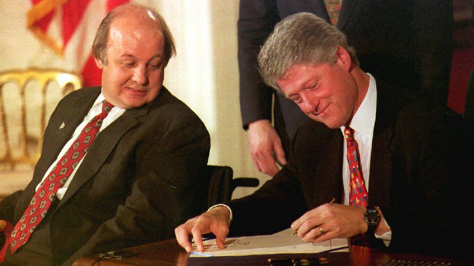 James Brady (izquierda) observa a Bill Clinton firmando la Ley Brady.