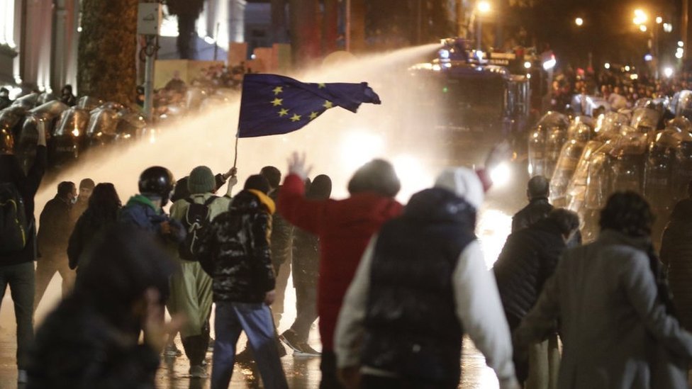 La policía antidisturbios usa cañones de agua y gases lacrimógenos para dispersar a manifestantes reunidos frente al edificio del parlamento durante una protesta contra el proyecto de ley sobre la transparencia de la influencia extranjera en Tiflis.