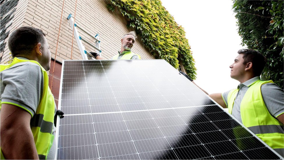 建築工人正在安裝太陽能電池板。