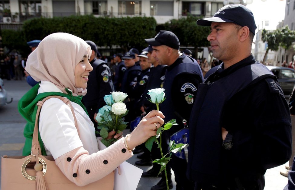 demonstrantkinja deli ruže poliicji