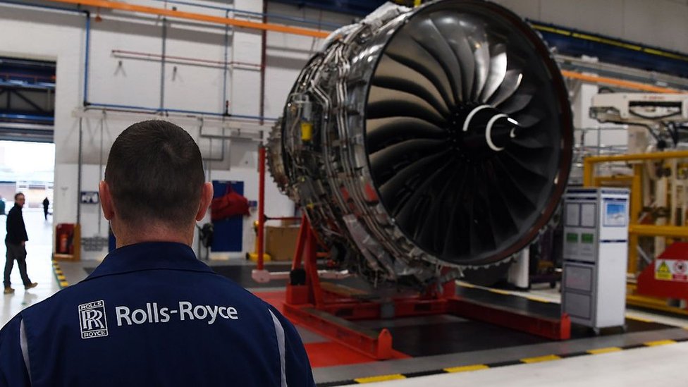 Рабочий Rolls-Royce стоит перед реактивным двигателем