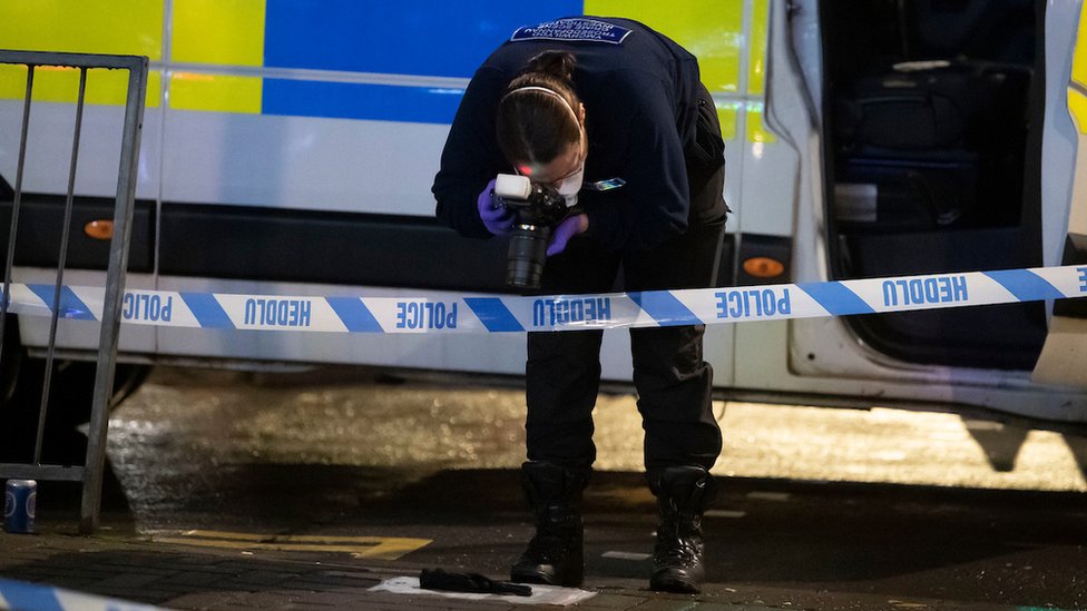 Officer photographs evidence on the ground