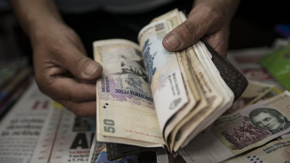 A newsstand owner counts Argentine pesos bills in Buenos Aires on January 24, 2014.