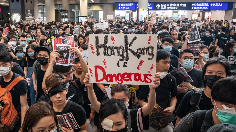 Протестующие занимают зал прибытия международного аэропорта Гонконга во время демонстрации