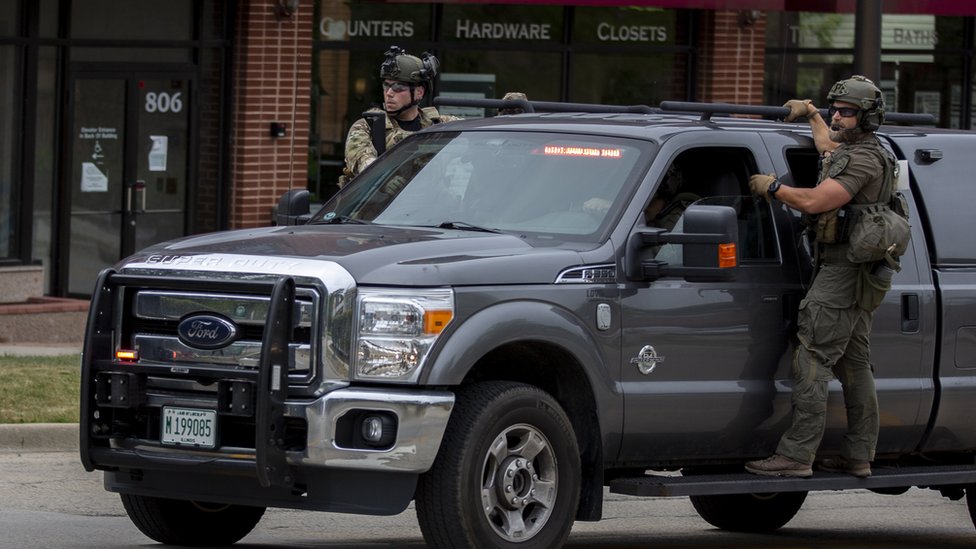 Image shows police officers with guns