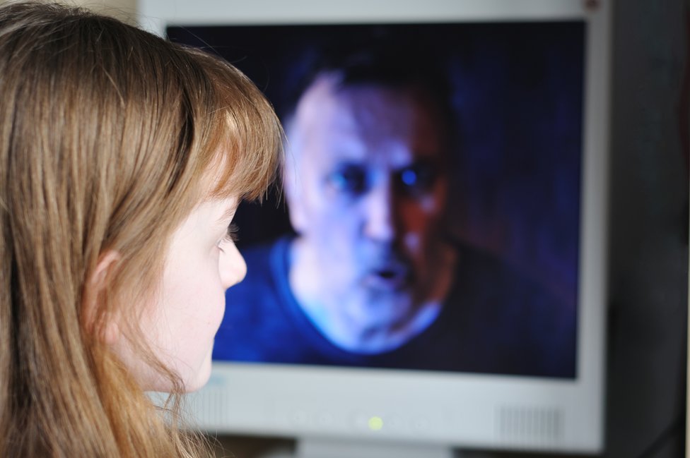 Девушки смотрят на лицо мужчины на экране компьютера