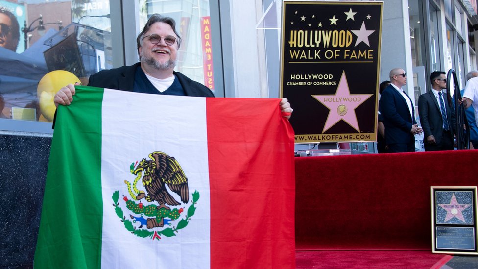 Guillermo del Toro con la bandera mexicana en el Paseo de la Fama.