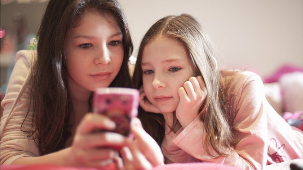 Adolescentes mirando un teléfono móvil