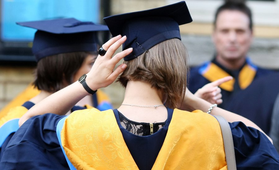 Anonymous rear shot of graduates wearing graduation robes