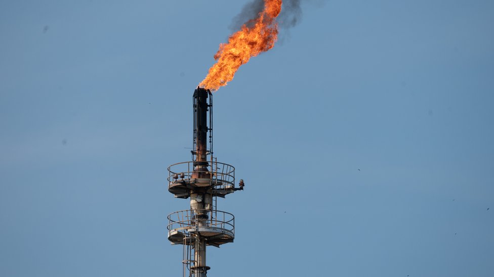 Una foto de una antorcha de una refinería quemando gas