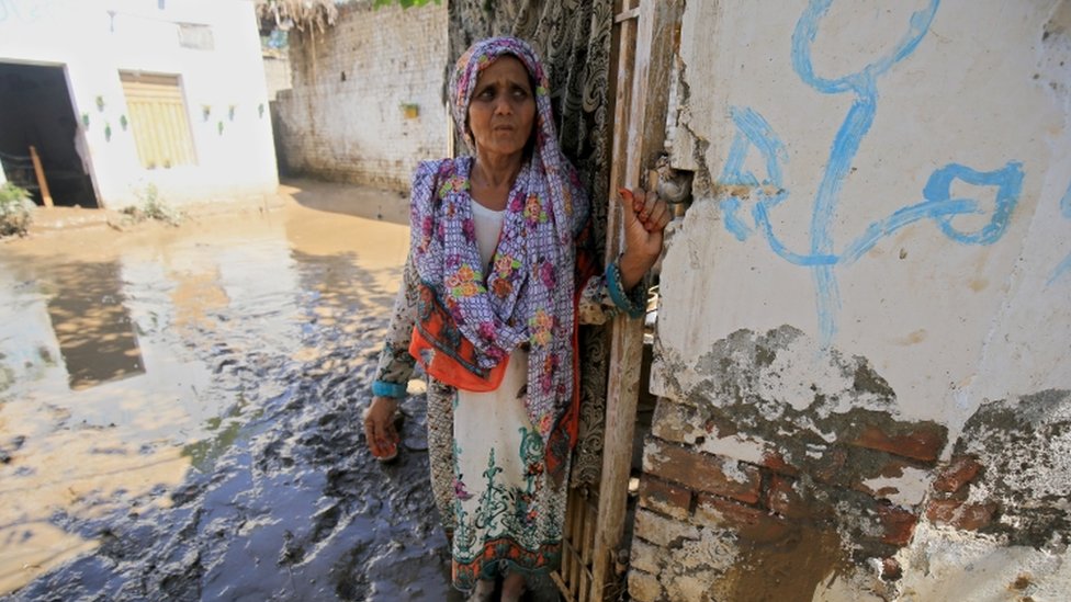 A woman stands outside her house in Charsadda district, Khyber Pakhtunkhwa province on 28 August
