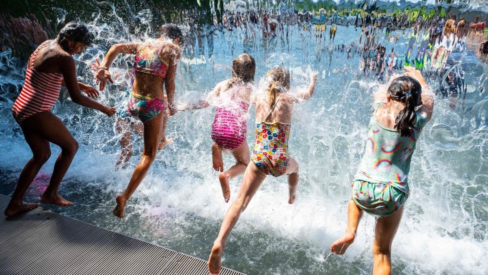 Niños refrescándose en una fuente de Richmond, Columbia Británica, 29 de junio de 2021