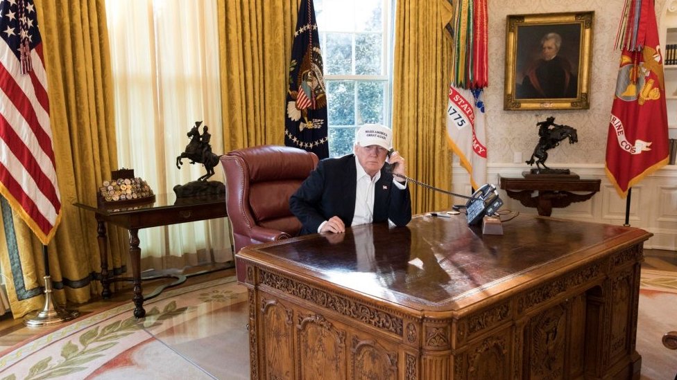 Donald Trump sits in the Oval Office