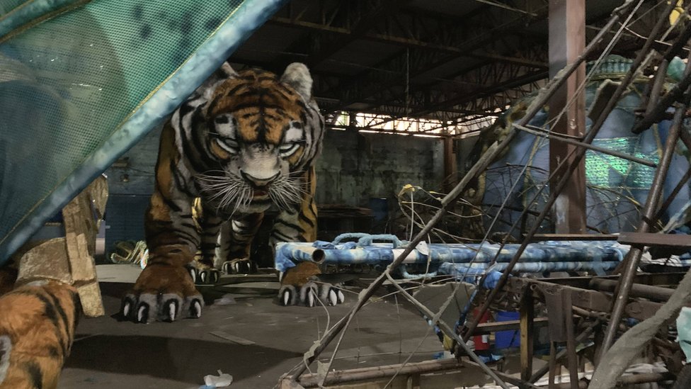 Большая модель тигра сидит в заброшенной школе самбы