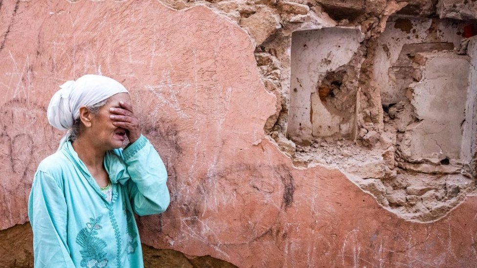 سيدة تبكي أمام منزلها المتضرر من الزلزال في المدينة القديمة في مراكش