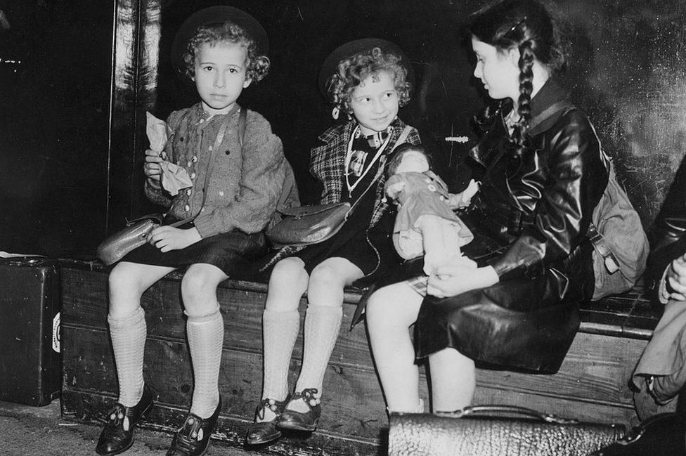 Fotografía en blanco y negro de tres niñas sentadas en un banco