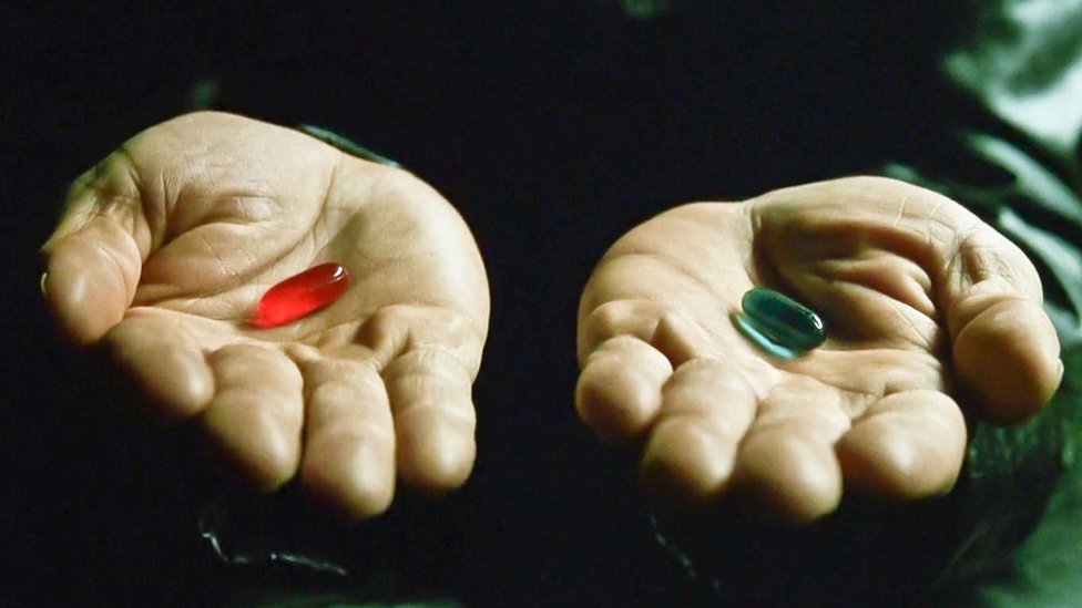 Las manos del personaje Morpheus ofreciendo a Neo las píldoras roja y azul