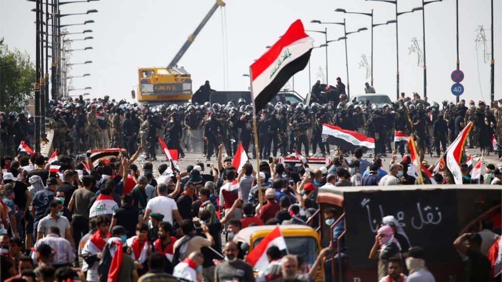 Силы безопасности Ирака стоят перед демонстрантами во время акции протеста против коррупции, отсутствия рабочих мест и плохого обслуживания в Багдаде, Ирак 25 октября 2019 г.