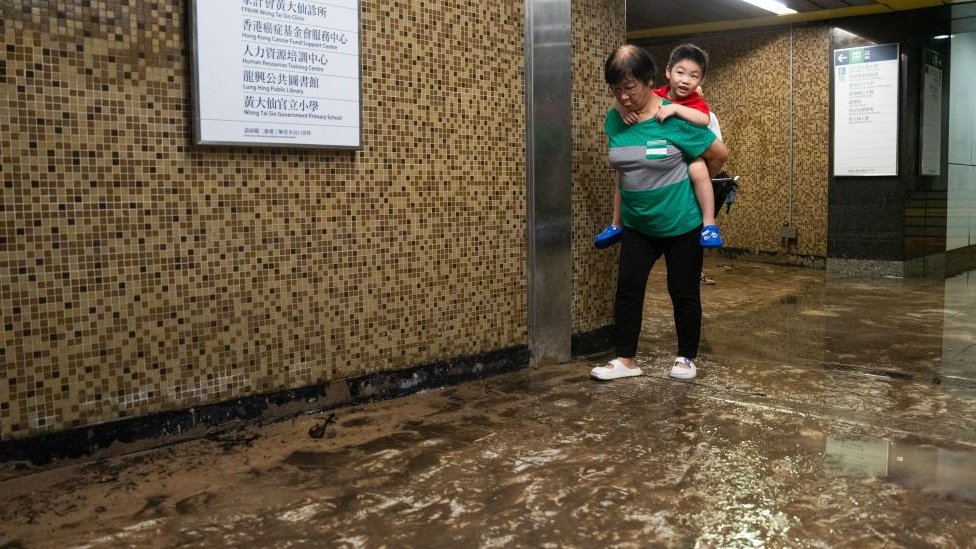 9 月 8 日，香港黃大仙地鐵站發生嚴重水災，一名兒童被背過泥濘的地面。
