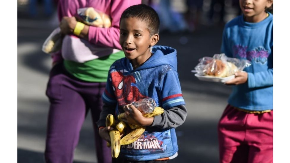 Niños migrantes con comida.