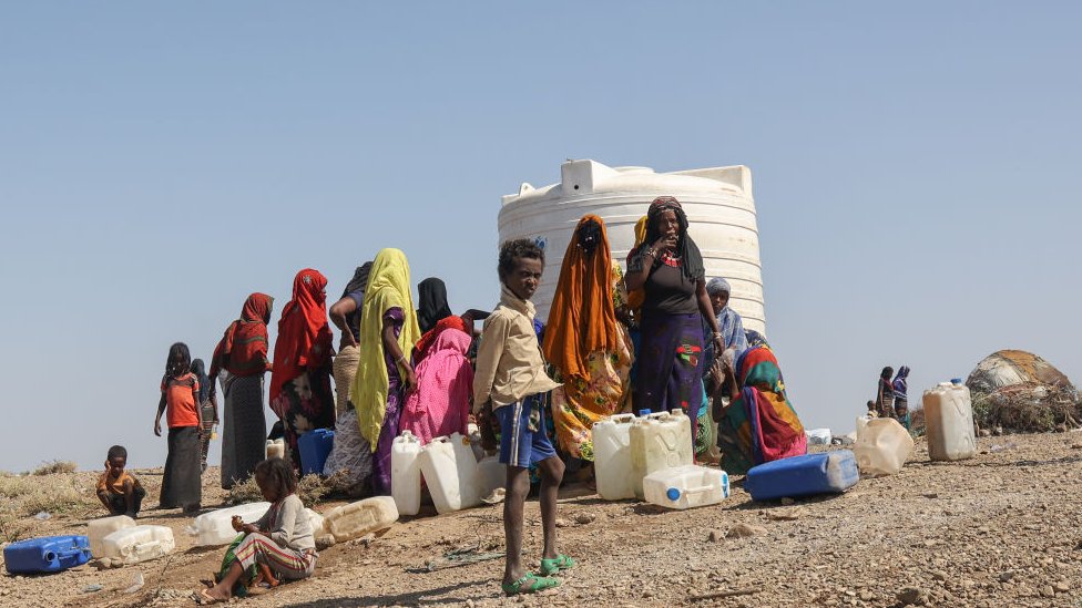 Etíopes agolpados alrededor de un tanque de agua.