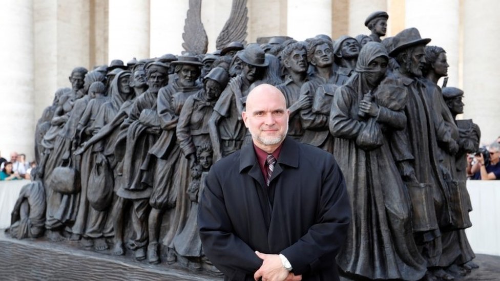 Тимоти П. Шмальц стоит перед скульптурой