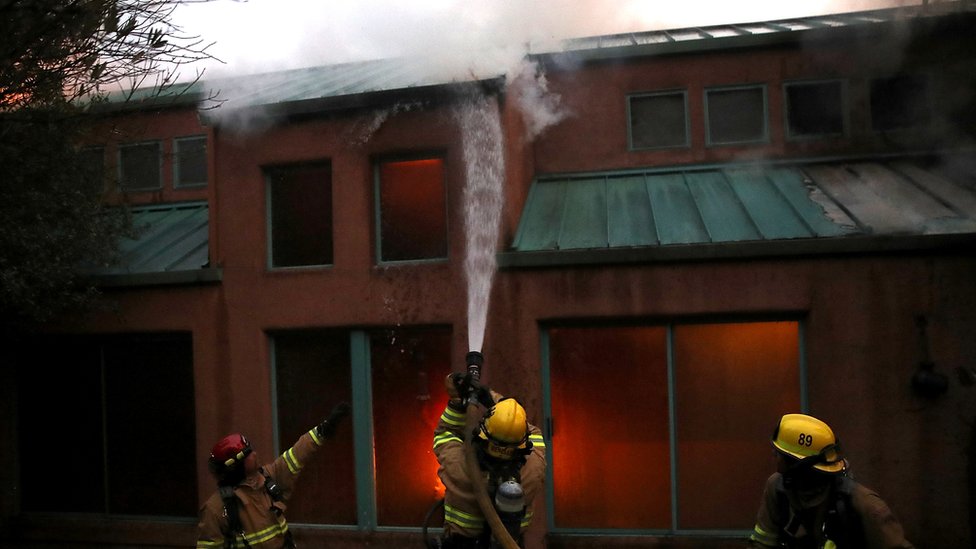 Пожарные пытаются тушить пожар в доме во время пожара Таббс 12 октября 2017 года недалеко от Калистоги, Калифорния