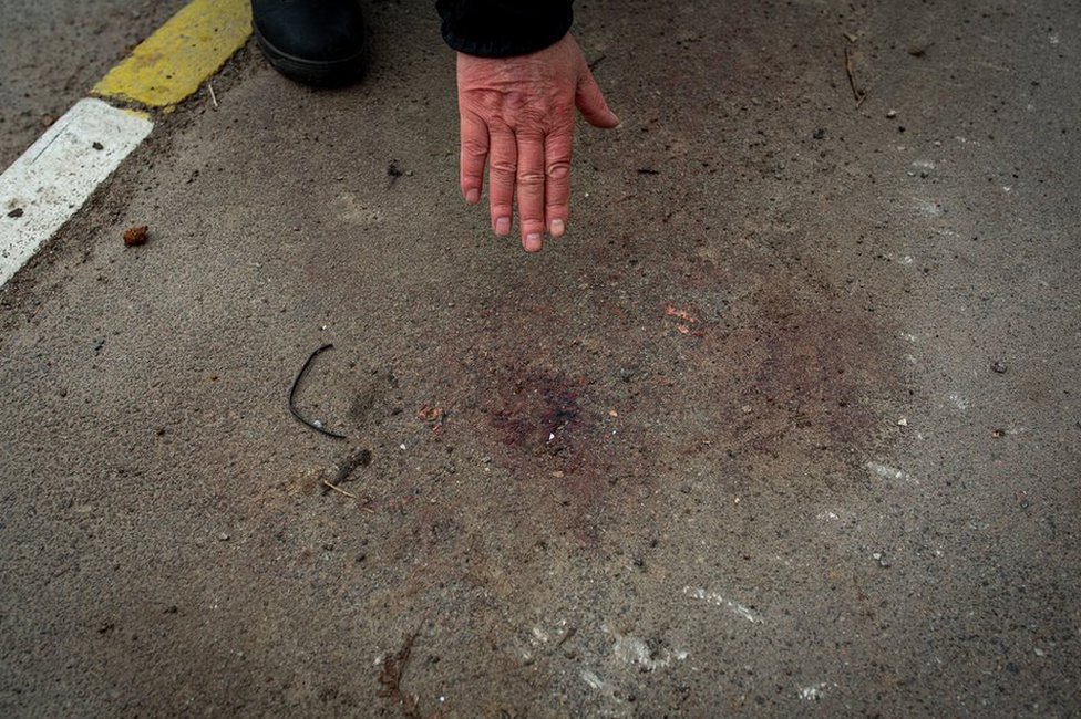 Vladimir Abramov pokazuje na mesto na trotoaru ispred njihove kuće gde kaže da je njegov zet bio prisiljen da klekne i gde mu je pucano u glavu