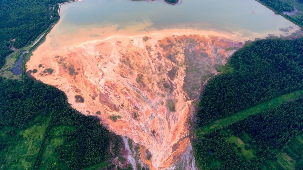 Una vista aérea tomada el 27 de junio de 2020 muestra ríos de color naranja que se abren en abanico sobre el paisaje boscoso cerca de una mina de sulfuro de cobre en desuso cerca del pueblo de Lyovikha, en los Urales.