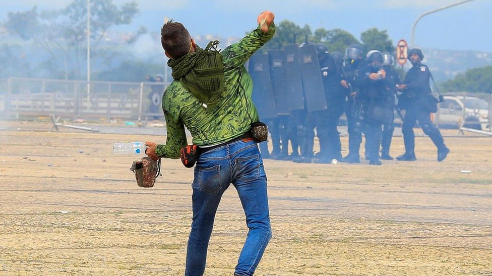 Un hombre arroja un objeto a policías durante la invasión en Brasilia.