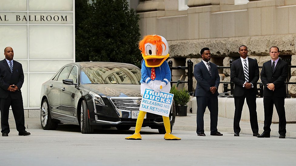 Человек в костюме Дональда Дака стоит возле отеля Трампа в Вашингтоне, округ Колумбия