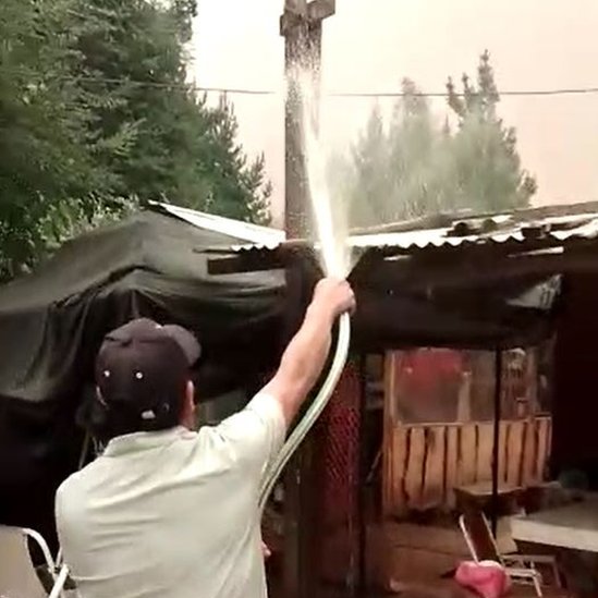 Yarko Cortés riega el techo como precaución contra las llamas