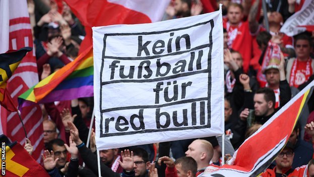 مشجعو بايرن ميونيخ يحملون لافتة كتب عليها "لا كرة قدم لـ ريد بُل"