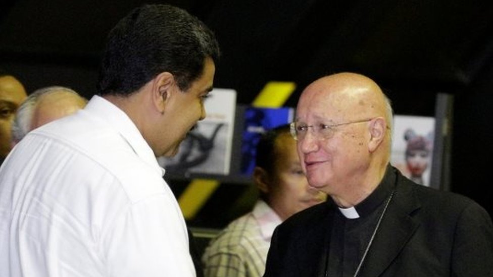 Президент Венесуэлы Николас Мадуро (справа) пожимает руку Клаудио Мария Челли (справа), представителю Ватикана, когда он прибывает на политическую встречу между правительством и оппозицией